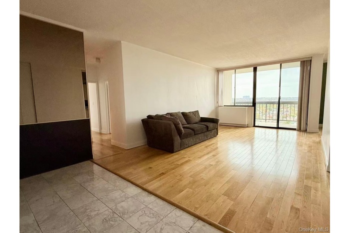 Living area featuring a wall of windows, light wood-style floors, and a textured ceiling