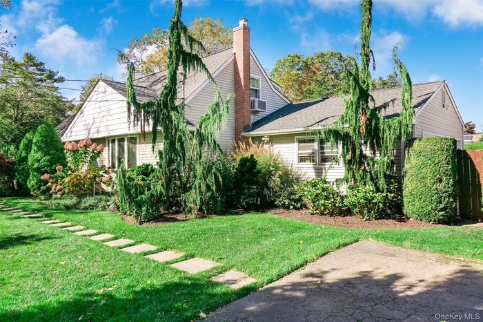 View of property exterior with a shingled roof, a yard, and a chimney