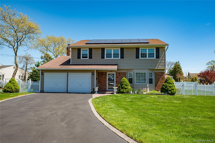 Traditional-style house featuring a gate, aphalt driveway, fence, a front yard, and solar panels