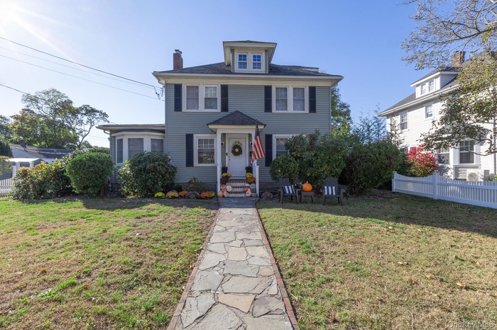 American foursquare style home featuring a chimney