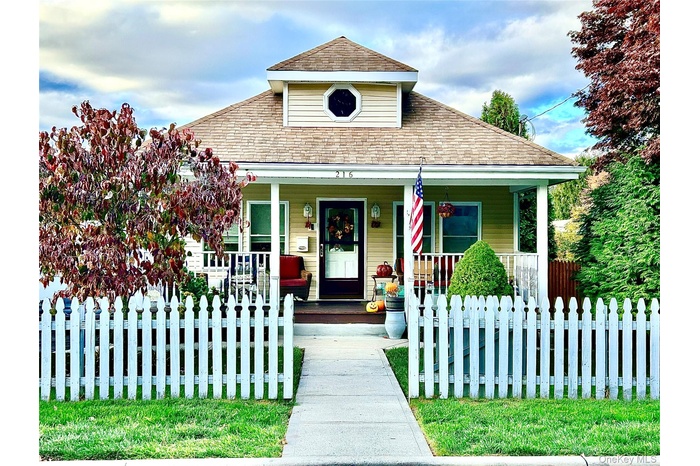 View of front of house featuring a porch and a fenced front yard