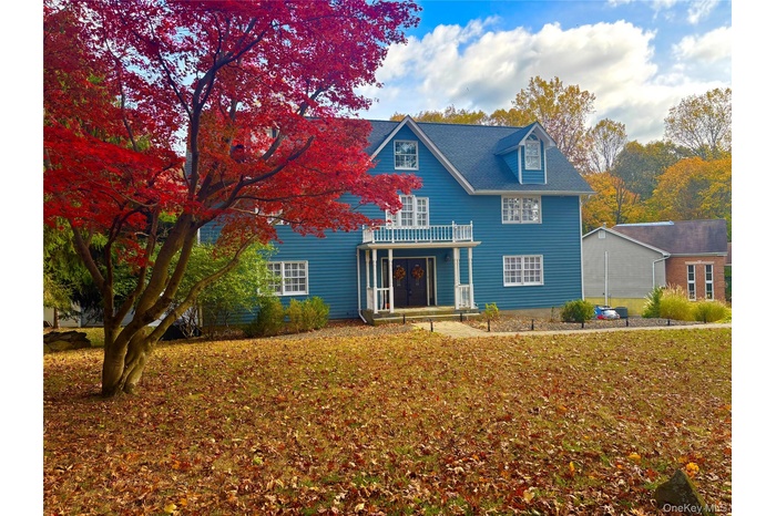 View of front of property featuring a porch and a front yard