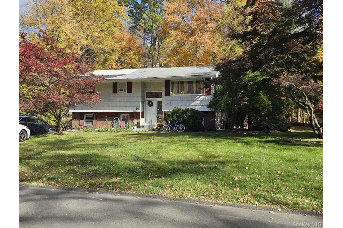 Bi-level home with a front lawn and brick siding