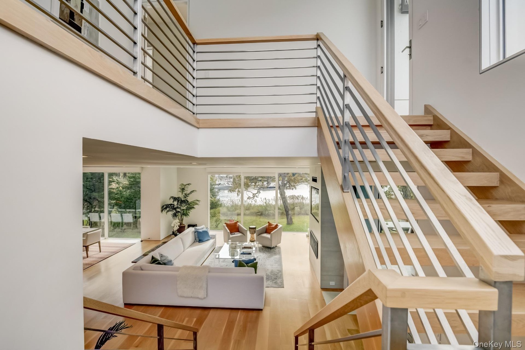Staircase with hardwood / wood-style floors and a towering ceiling