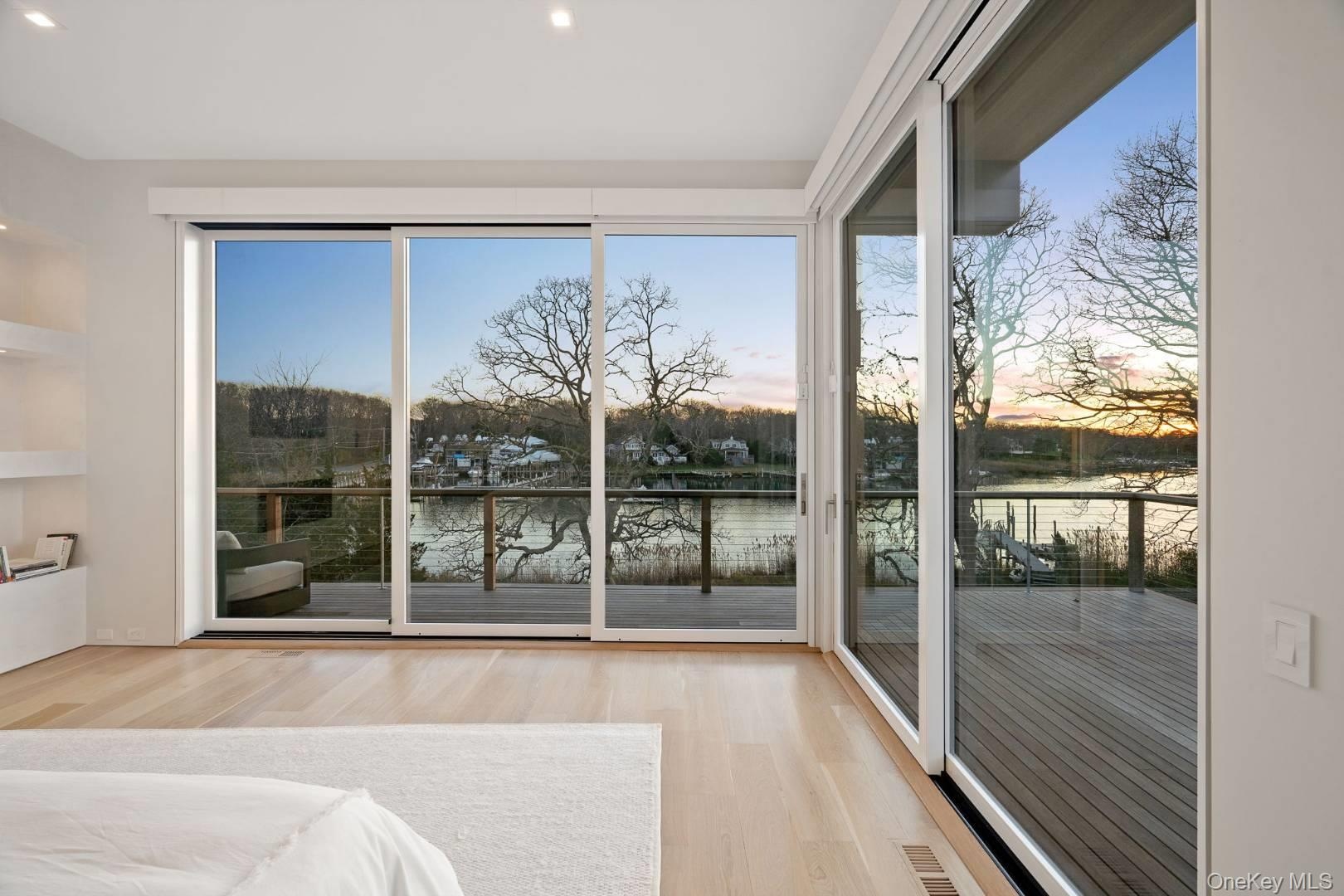Unfurnished bedroom with access to outside, a water view, and light hardwood / wood-style floors
