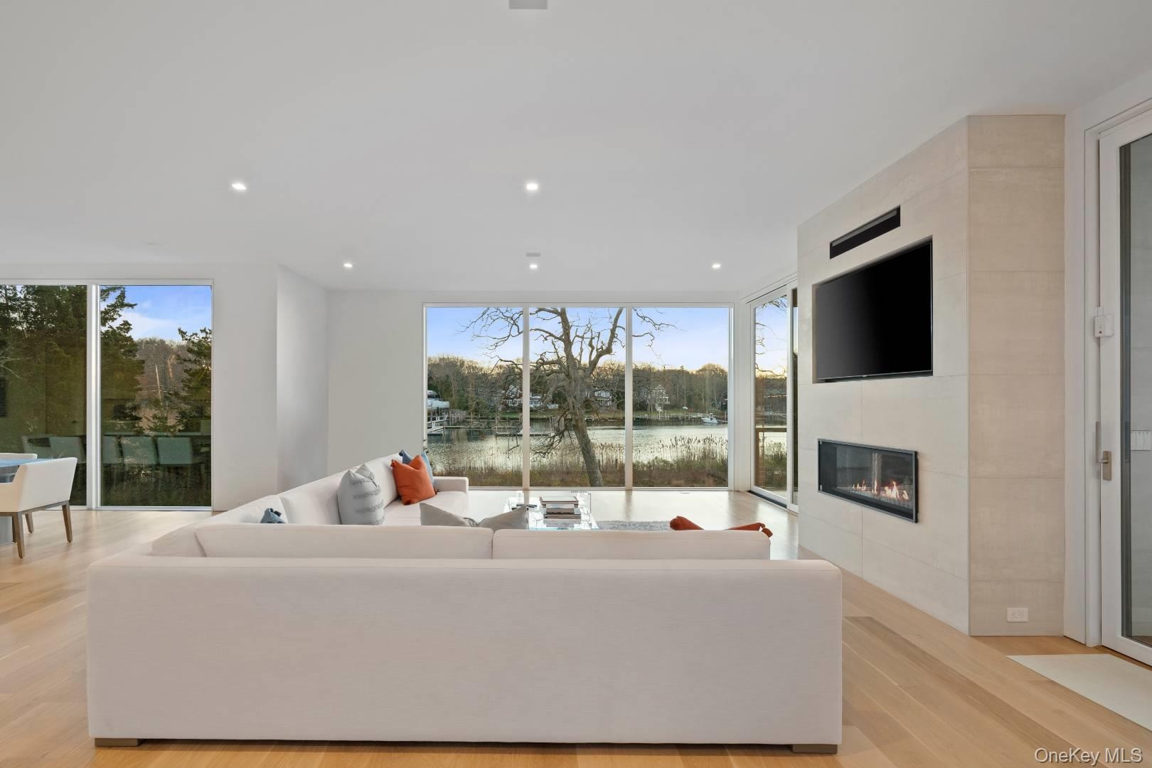 Living room featuring a tile fireplace, light hardwood / wood-style flooring, and a wealth of natural light