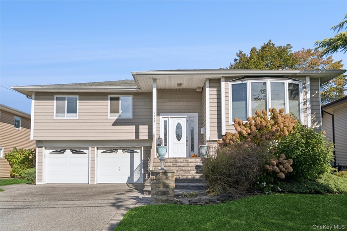 Raised ranch featuring driveway and an attached garage