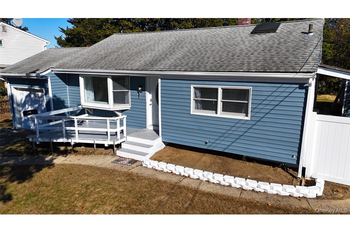 View of front of house with a shingled roof and a chimney
