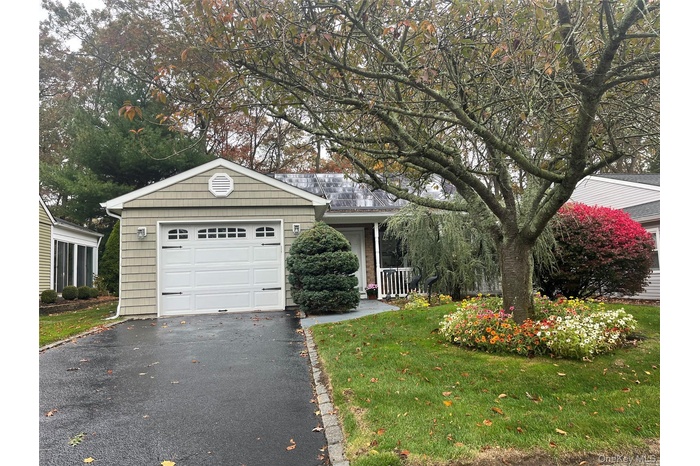 View of front of home Beautifully Landscaped with driveway, a front porch, and an attached garage