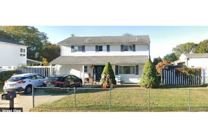 Traditional-style house featuring a fenced front yard, a garage, and covered porch