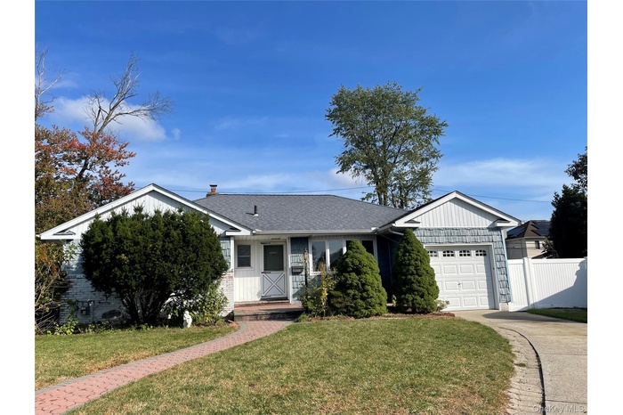 Ranch-style home with a garage, driveway, roof with shingles, and board and batten siding