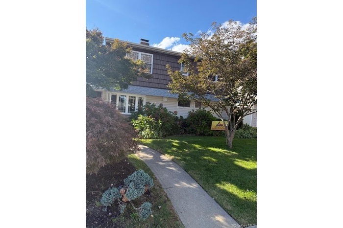 View of front of property with a chimney and a front yard