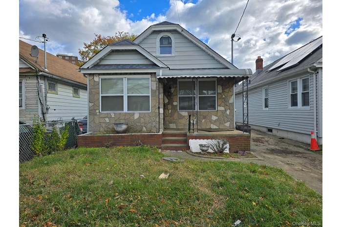 Bungalow-style home with stone siding and a porch