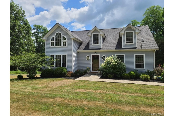 View of front of property with a front yard and roof with shingles