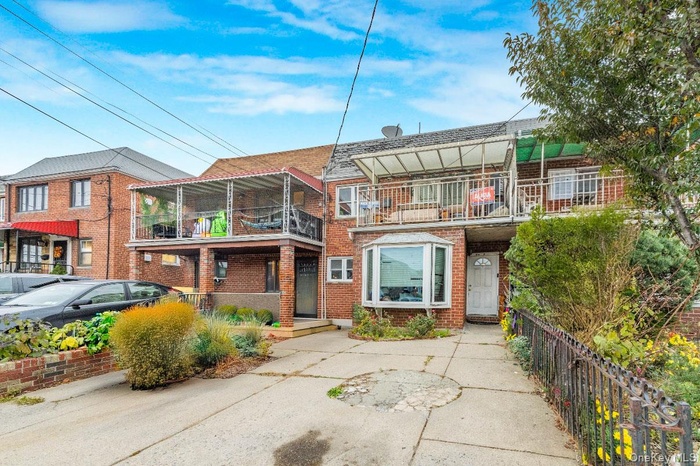 View of front of home with a balcony and brick siding