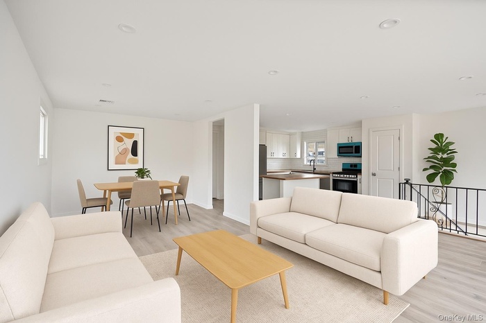 Living area featuring light wood finished floors and recessed lighting
