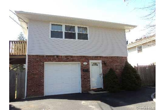 View of front facade featuring brick siding and a garage