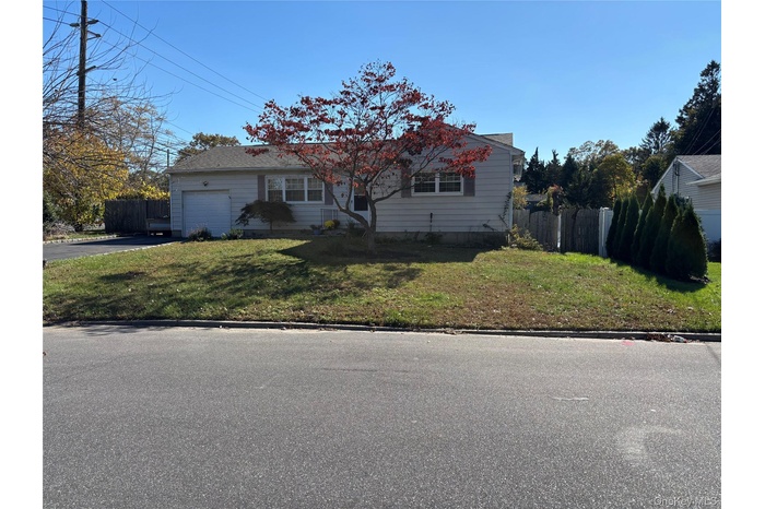 View of front of home with an attached garage and asphalt driveway