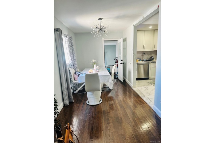 Dining room featuring an inviting chandelier, baseboards, and wood finished floors