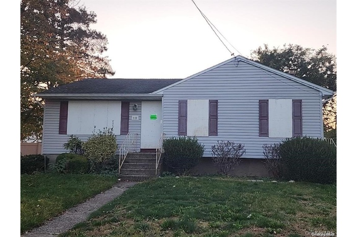 View of front of property featuring a front yard and roof with shingles