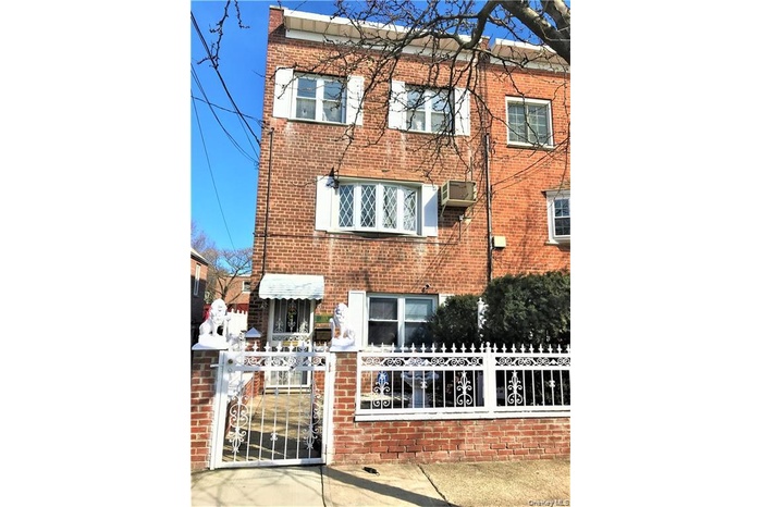 View of front of property featuring a fenced front yard, brick siding, and a gate
