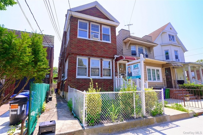 View of front of house with brick siding and a fenced front yard