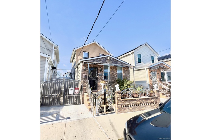 View of front facade with a gate, brick siding, and a fenced front yard