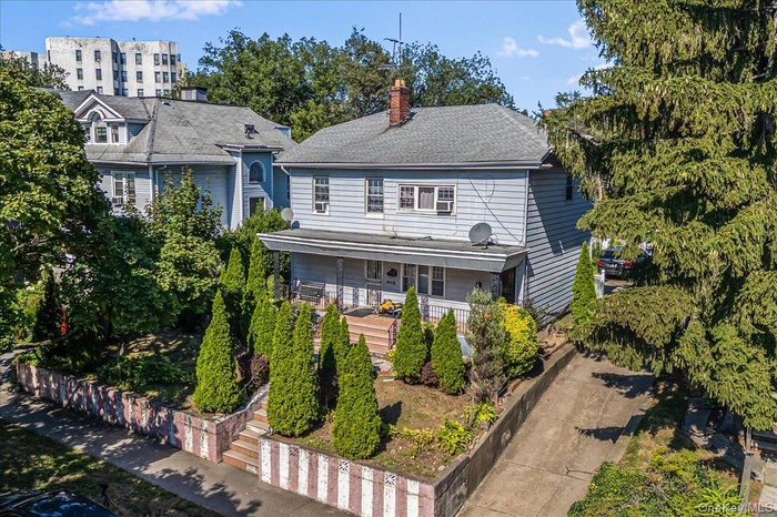 View of front of property featuring a chimney and a shingled roof