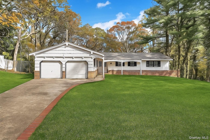 Ranch-style home featuring concrete driveway, brick siding, and a shingled roof