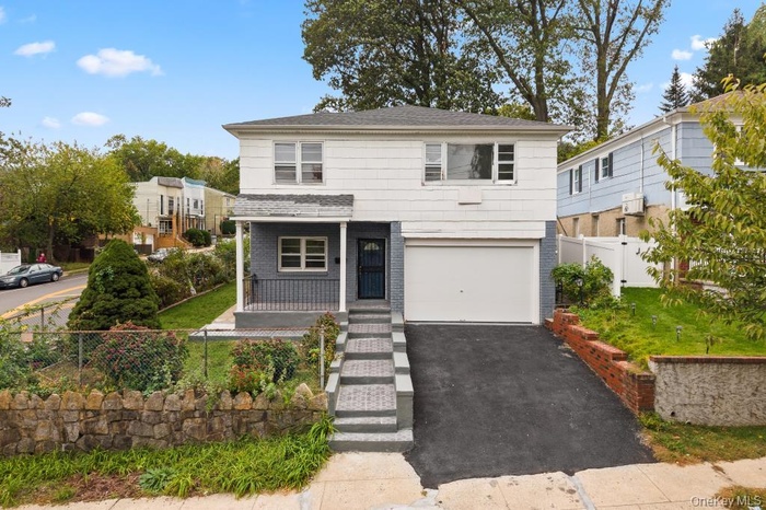 Traditional home featuring covered porch, an attached garage, brick siding, and driveway