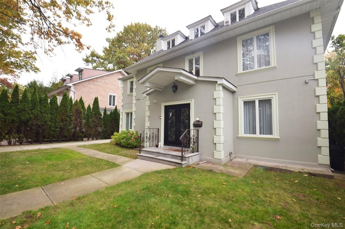 American foursquare style home with a front yard and stucco siding