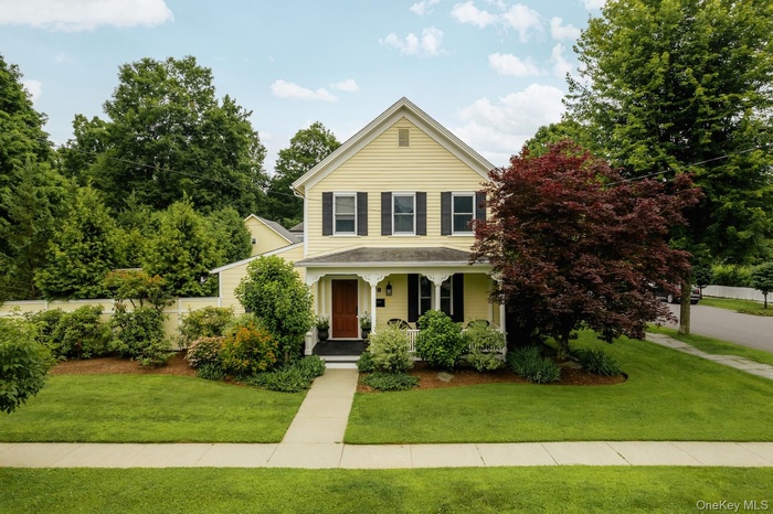 Traditional-style house with a porch and a front yard