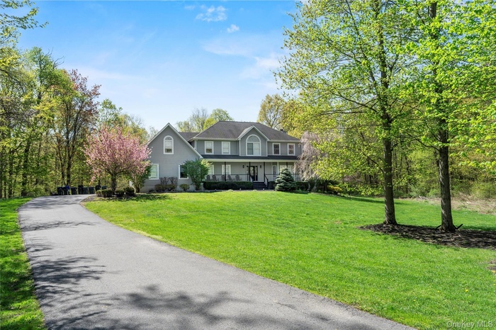 View of front of home featuring covered porch and a front yard