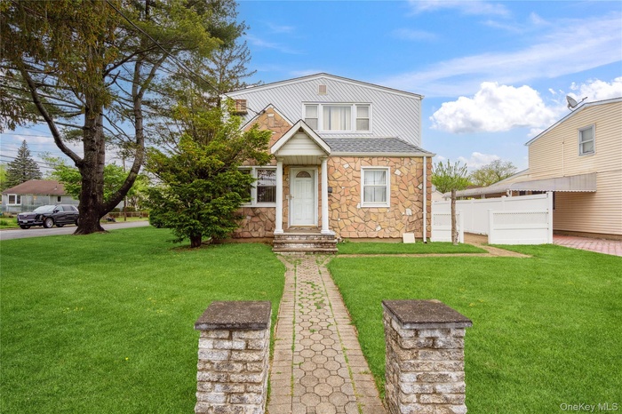 View of front of home with stone siding and a shingled roof