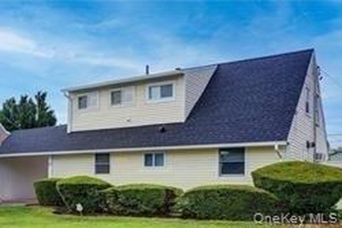 View of front of house with a front yard and a carport