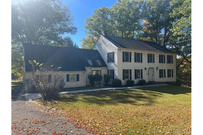 Colonial home featuring a front yard