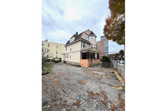 View of property exterior with a chimney, a gate, and covered porch