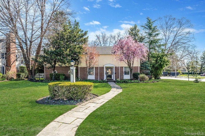 View of front facade featuring a front yard and brick siding