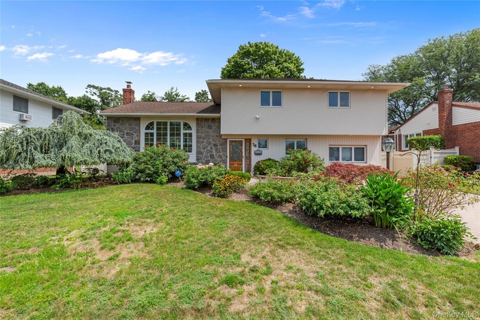 View of front of property featuring a chimney and stone siding