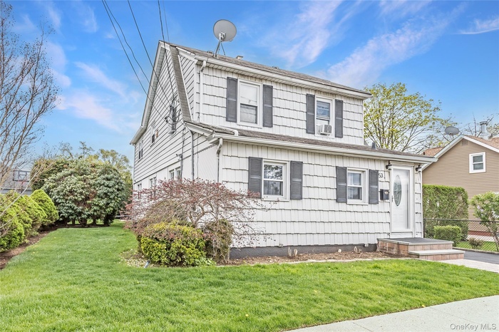 Traditional-style house with fence, a front yard, and cooling unit