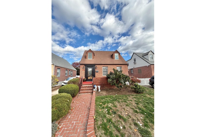 View of front of house featuring brick siding and a front yard