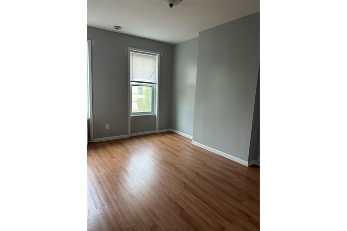 Spare room featuring light wood finished floors and baseboards