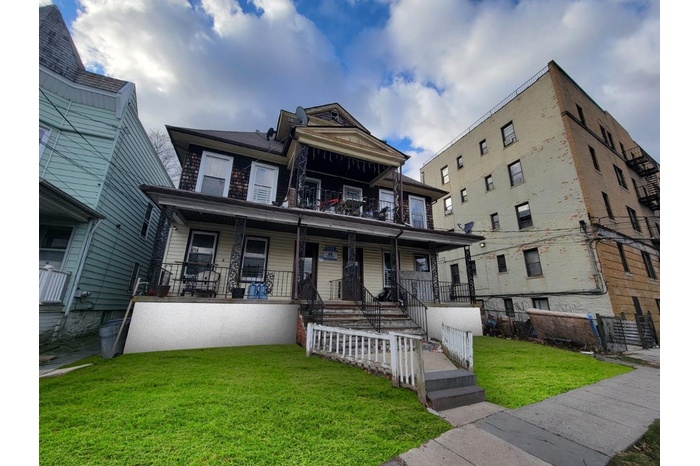 Townhome / multi-family property with a porch and a front lawn