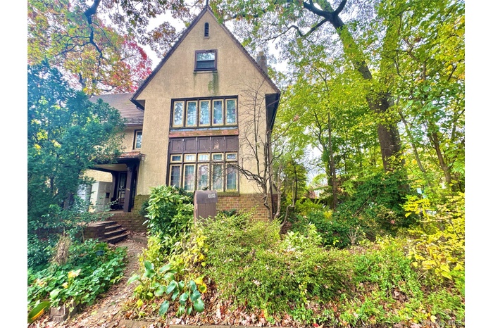Rear view of house featuring stucco siding and brick siding