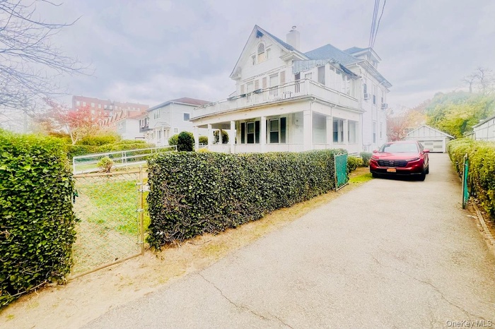 View of home's exterior featuring a chimney, covered porch, and a balcony