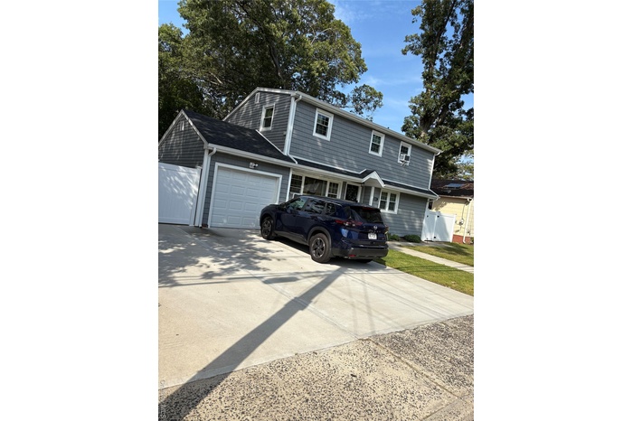 View of front of property with driveway and an attached garage