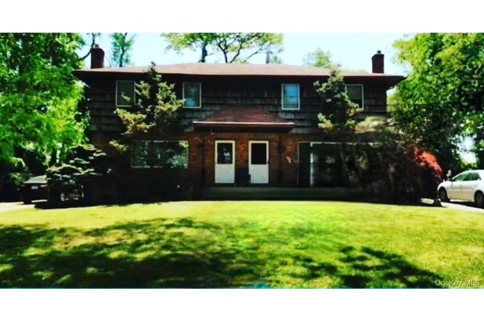 View of front of home featuring a chimney and a front lawn