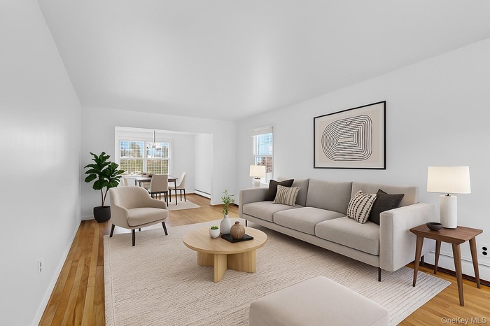 Virtually staged Living area with light wood-style floors and baseboards