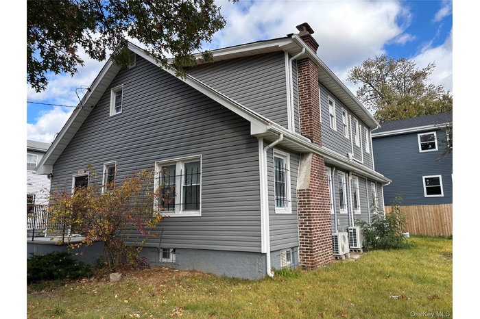 View of side of property featuring a cooling unit and a chimney