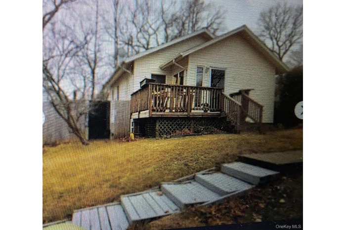 Back of house featuring a wooden deck